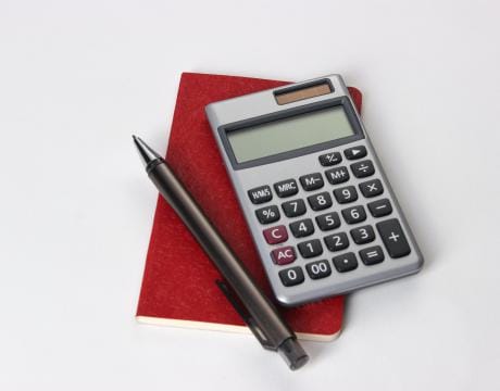 A calculator and a notebook on a white background.